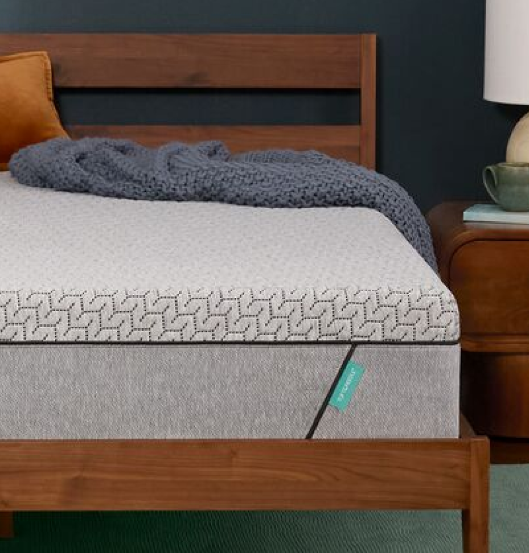 close up of the tuft & needle mint mattress in a bedroom with knit blanket
